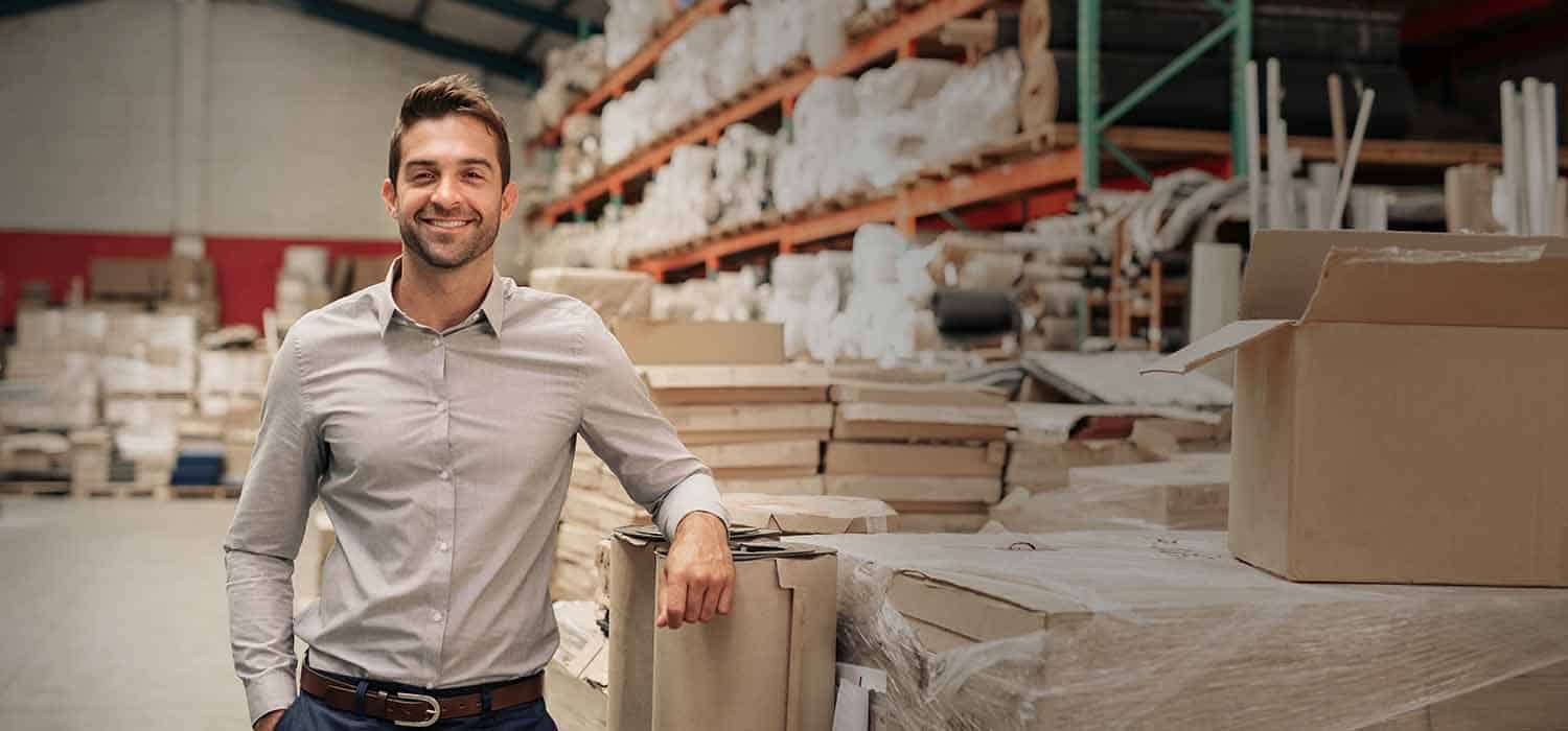 manufacturing logistics managing director standing in warehouse using safety remotely software